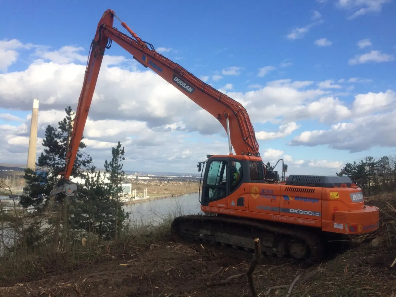 Pelle à bras de 23 mètres sur un talus dominant la ville
